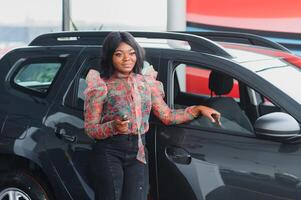 Beautiful young mixed race black African American woman driving car and show holding the key photo