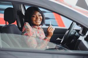 Beautiful young mixed race black African American woman driving car and show holding the key photo