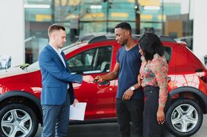 contento mujer recepción un nuevo coche desde su marido a concesión foto