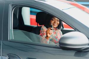 Beautiful young mixed race black African American woman driving car and show holding the key photo