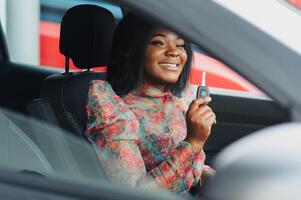 Beautiful young mixed race black African American woman driving car and show holding the key photo