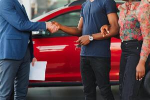 young african couple buying new car at dealership photo