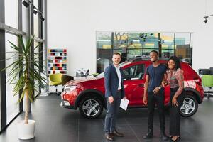 young african couple buying new car at dealership photo