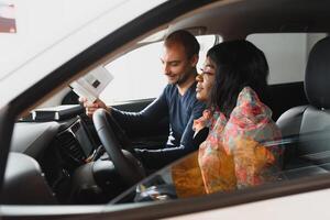 beautiful young african woman buying a car at dealership photo