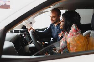 beautiful young african woman buying a car at dealership photo