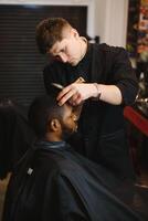 Visiting barbershop. African American man in a stylish barber shop photo