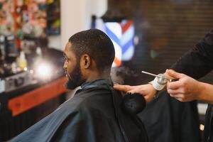 joven afroamericano hombre visitando barbería foto