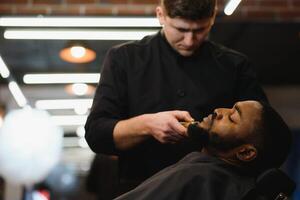 Black man in the barbershop. Cute black man makes a haircut in the African salon. Hair style. Haircut for adults. photo