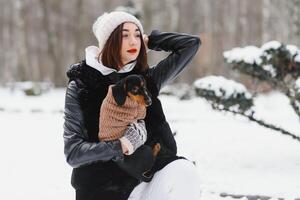 The girl walks with a dog in the winter. photo