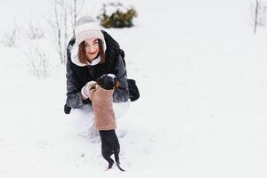 Young stylish woman with a dog having fun in a winter forest. photo