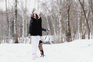 mujer es caminando durante invierno con su perro foto