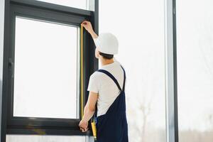 trabajador de la construcción instalando ventana en casa foto