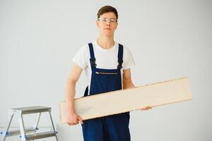 trabajador con materiales para instalando laminado piso foto