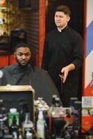 joven afroamericano hombre visitando barbería foto