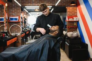 joven afroamericano hombre visitando barbería foto