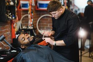 Young African-american man visiting barbershop photo