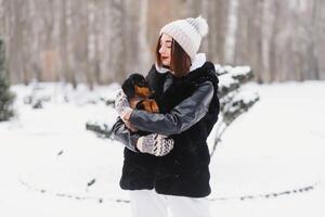 Young stylish woman with a dog having fun in a winter forest. photo