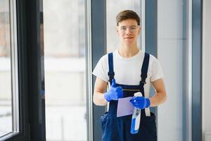 limpieza Servicio llegó a limpiar nuevo casa. trabajo duro hombre cuidadosamente limpiar ventana. lado ver foto