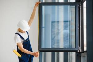 Professional handyman installing window at home. photo