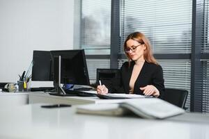 Portrait of successful female sitting in office photo