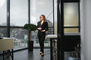 Confident business woman stands in the office photo