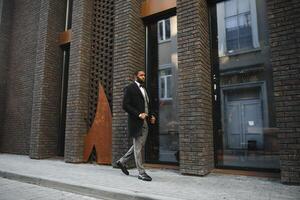 Retrato de un empresario afroamericano que llevaba un traje de pie en un entorno empresarial al aire libre foto