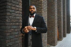 Young african american businessman drinking take away coffee at the city. photo