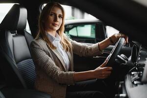 Photo of happy young woman sitting inside her new car. Concept for car rental.