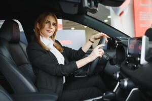 young beautiful business woman sitting in her car. photo