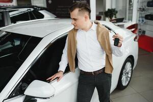 joven hombre con el llaves a el coche. foto