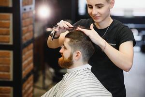de cerca, Maestro peluquero lo hace peinado y estilo con tijeras y peine. concepto barbería foto
