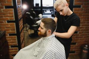 Close-up, master hairdresser does hairstyle and style with scissors and comb. Concept Barbershop photo