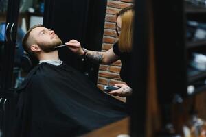 cliente durante barba afeitado en Barbero tienda foto