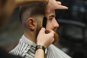 cerca arriba imagen de Barbero afeitado un hombre con un agudo acero maquinilla de afeitar foto