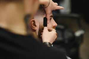 cerca arriba imagen de Barbero afeitado un hombre con un agudo acero maquinilla de afeitar foto