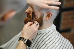 cerca arriba imagen de Barbero afeitado un hombre con un agudo acero maquinilla de afeitar foto