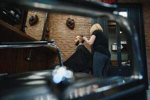 Barbero mujer corte hombre pelo a el peluquería. mujer trabajando como un peluquero. pequeño negocio concepto foto