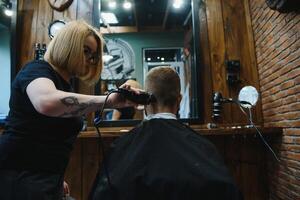 Barbero mujer corte hombre pelo a el peluquería. mujer trabajando como un peluquero. pequeño negocio concepto foto