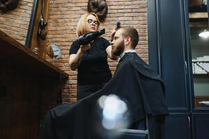 Barber Woman Cutting Man Hair at the Barbershop. Woman Working as a Hairdresser. Small Business Concept photo