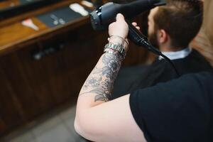 Serving client in Barbershop. Professional barber girl, female hairdresser making modern haircut for a man sitting in barber shop chair. Focus on a girl. Hairdressing, shaving, trimming, grooming. photo