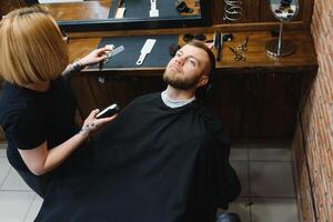 Client during beard shaving in barber shop photo