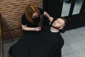 cliente durante barba afeitado en Barbero tienda foto