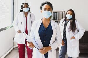 Group of African American female doctors in protective masks on their faces. photo