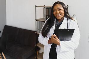 Portrait Of Smiling Female Doctor Wearing White Coat With Stethoscope In Hospital Office. photo