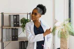 Young beautiful African American girl doctor in a white coat with a stethoscope. photo