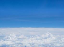 Aerial view of the sky and clouds are seen through the airplane window photo