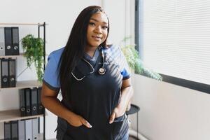 joven hermosa africano americano niña médico en un blanco Saco con un estetoscopio. foto