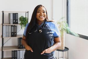 Young beautiful African American girl doctor in a white coat with a stethoscope. photo