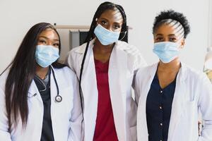 Group of African American female doctors in protective masks on their faces. photo