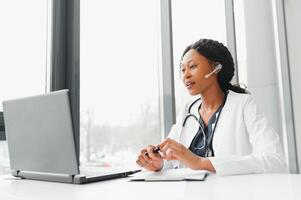 Pretty young smart female doctor or therapist giving health care advice online by webcam chat and consulting distant patient. Remote medical services. Telemedicine photo